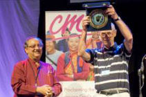 Canon Dr John Thew holding his award after receiving it from Bishop Mouneer