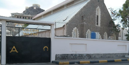 View of the church that stands behind the large black gate into the compound