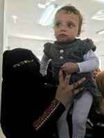 A toddler’s mother shows off her child to the visitors