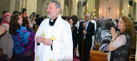 Reverend Faiz Jerges leads the procession up the aisle of the church