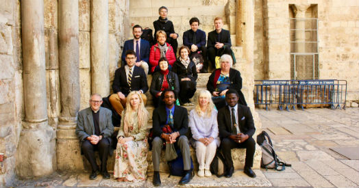The interns and their mentors sitting on steps in Jerusalem