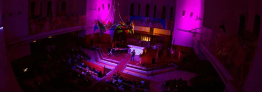 Looking down on the concert and audience with pink and purple lighting