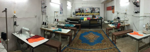The sewing room, machine tables along both side walls