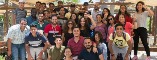A group photo under a canopy for shade