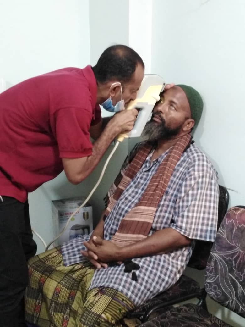 One of the clinical staff looking into a patient's eye