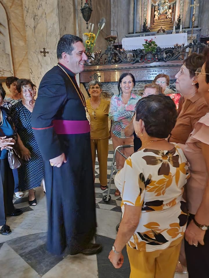 The archbishop stands in front of the altar talking with the Christians who were praying in St Elijah's cave