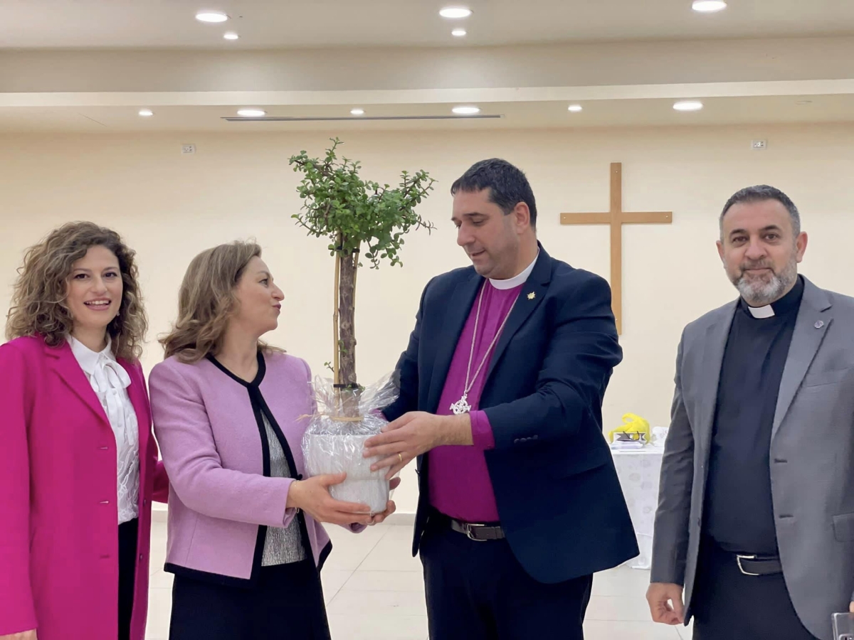 Mrs Lulu Nassar presenting the pot plant to Bishop Hosam alongside her Mrs Naoum and the Reverend Diab
