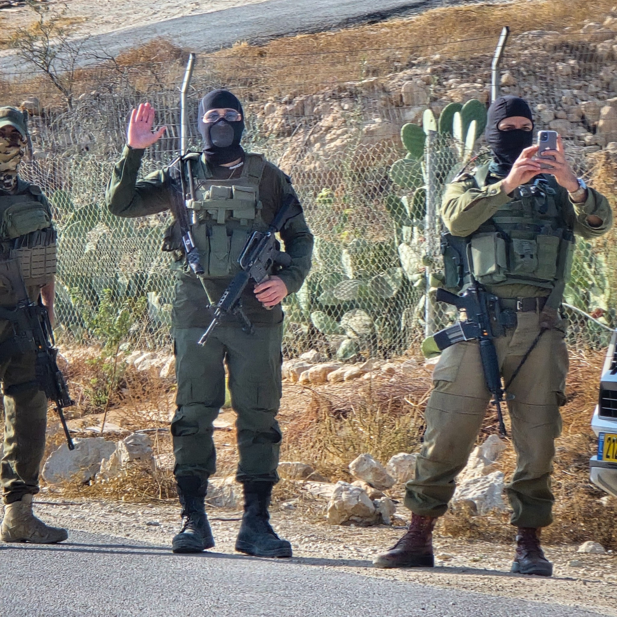 armed settlers watch the archbishop's visit