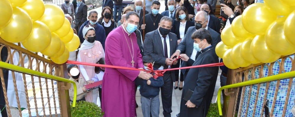 Archbishop Hosam cuts the ribbon across the stairs leading to the new upper floors
