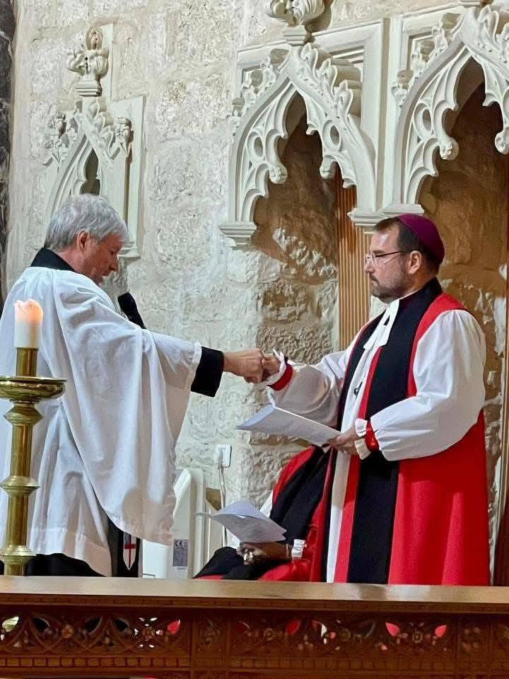 Bishop Sean is placed in his stall by Canon Dr Don Binder