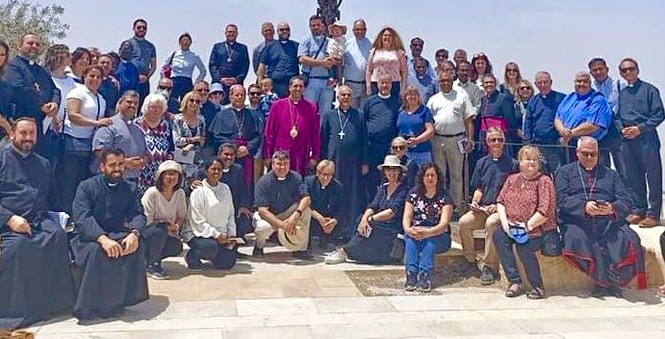The delegates gathered in front of the Cross-Serpent of Moses overlooking the Dead Sea at Mount Nebo