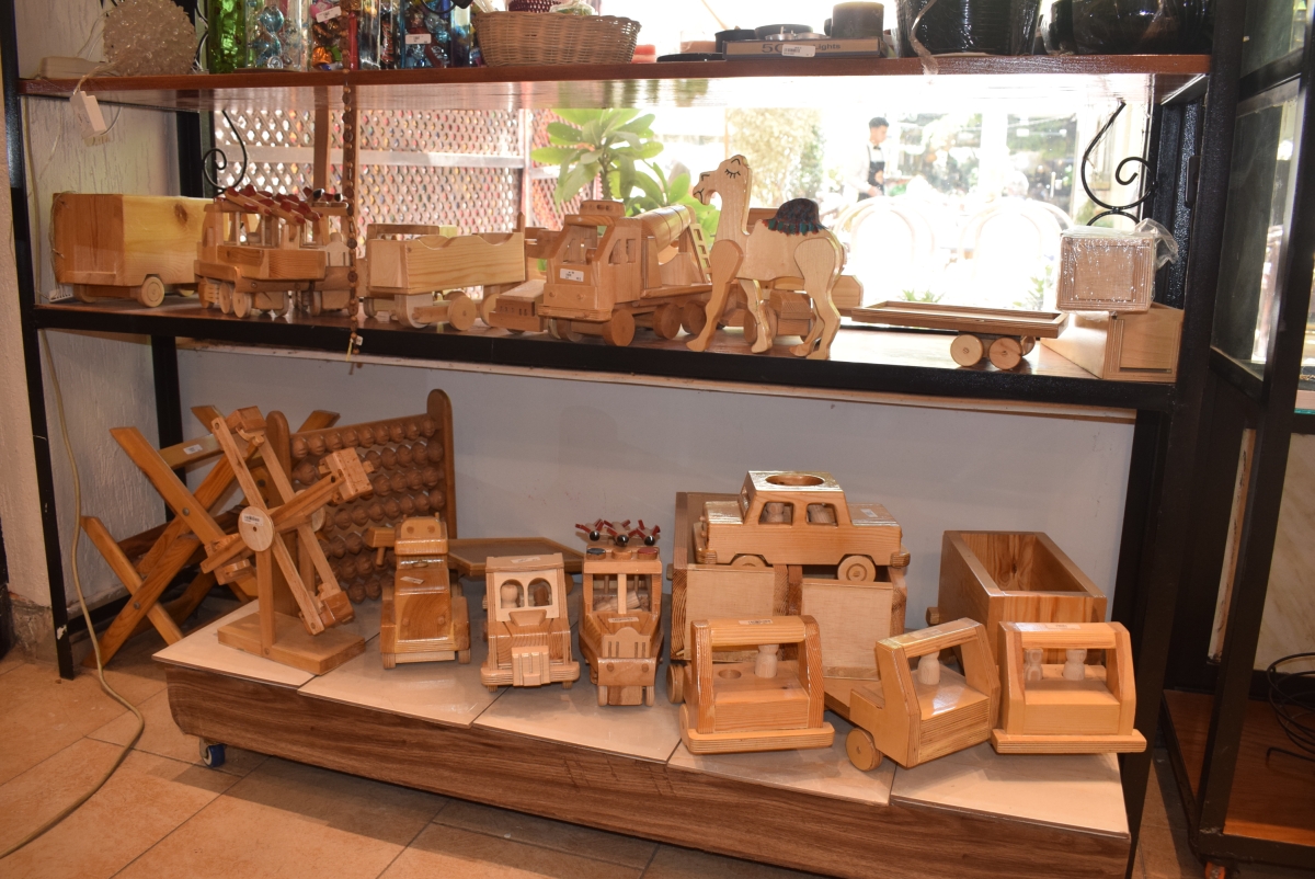 The display of woodcraft items in the Cathedral shop, including a wooden ferris wheel, an abacus, wooden trucks and a wooden camel