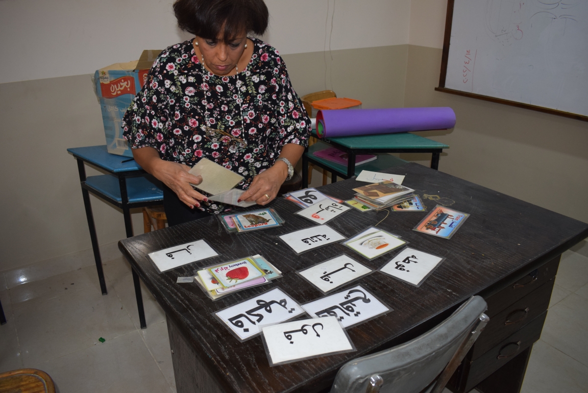 A teacher prepares picture and word flashcards for a lesson
