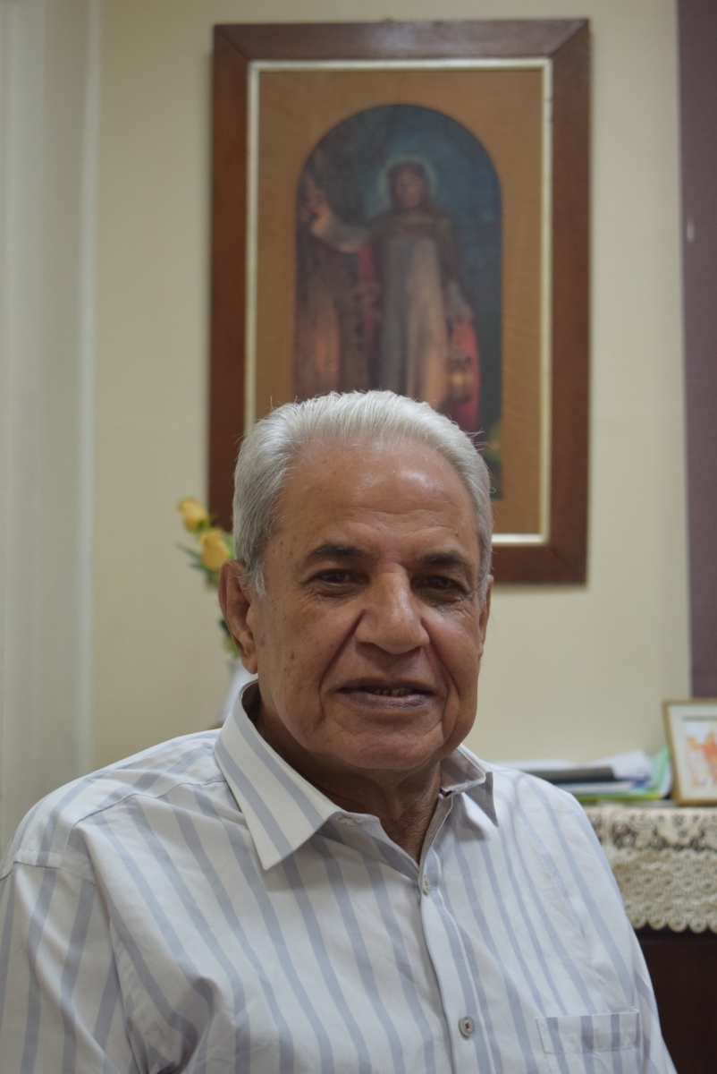 Portrait of Dr Samir Mansour, the Hospital Director, sitting in front of the picture of Jesus. Light of the world