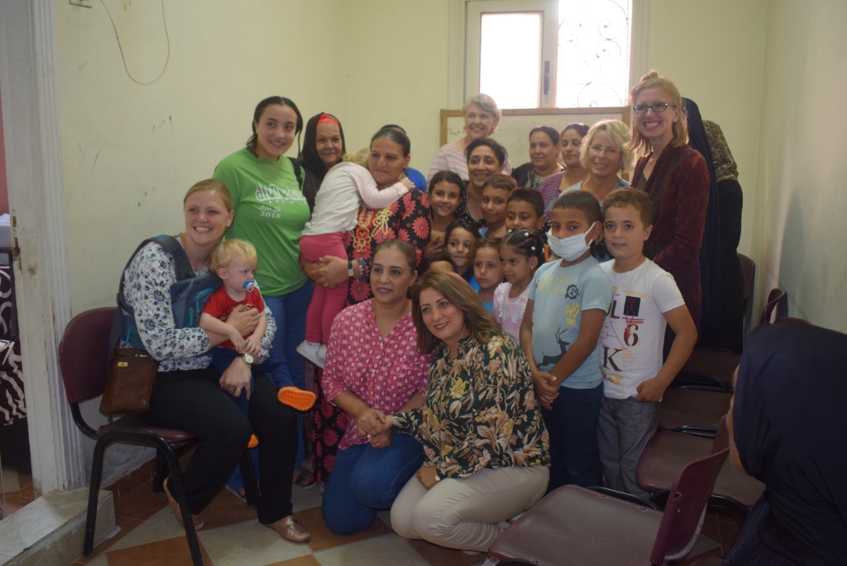 The group poses with mothers and children at the Ras al Soda Family Centre