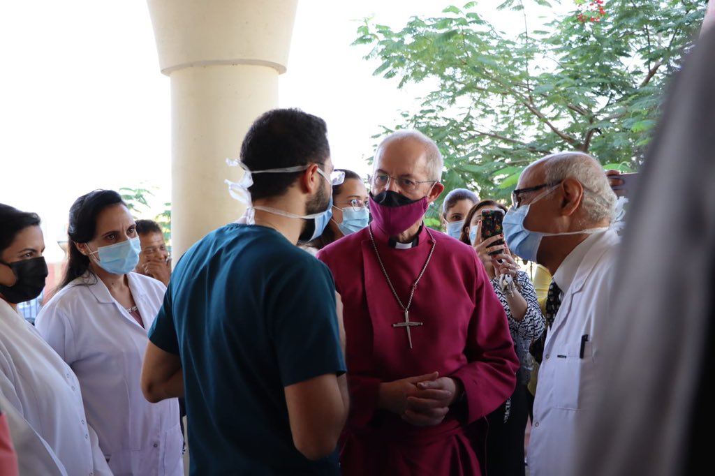 Justin Welby wearing a protective face mask speaking to Drs outside the clinic