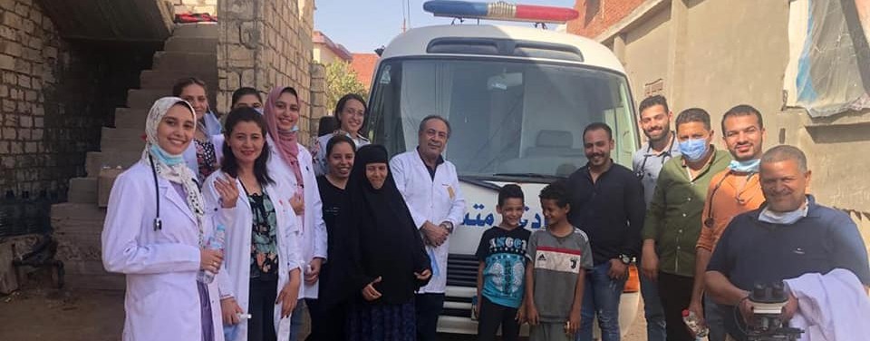 The team of medics standing in an arc in front of the medical van with some of the patients they met