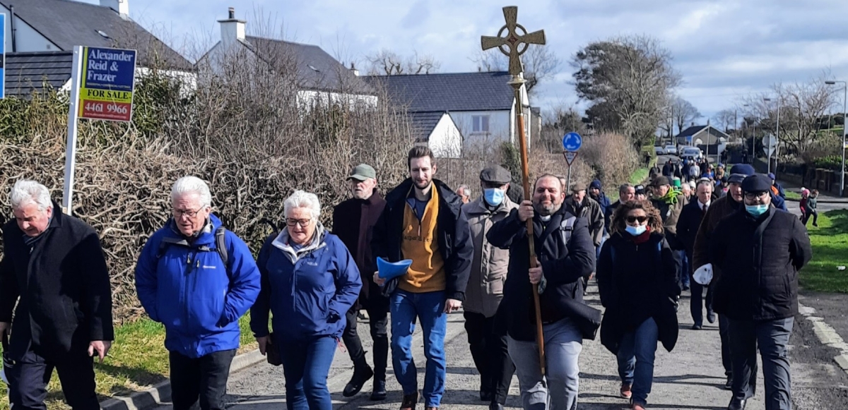 Pilgrimage procession carrying the cross up a local road