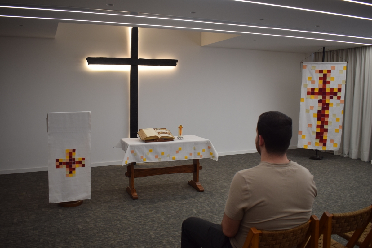 Saba sat in the Kenneth Bailey chapel, the bible open on a table in front of la rge cross that is surrounded by light