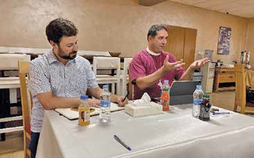 Joel Kelling and Archbishop Hosam Naoum sitting at a table during the conference