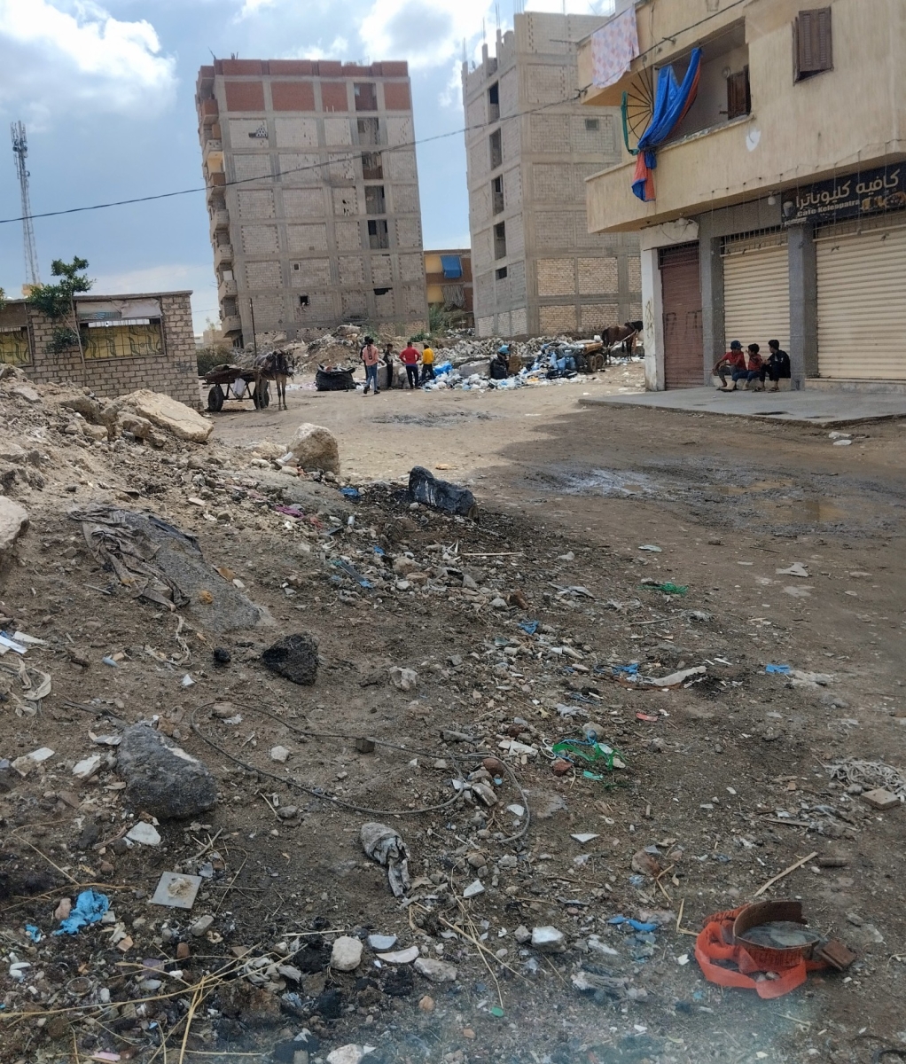 street scene of Ras al Soda showing rubble, rubbish and a horse and cart